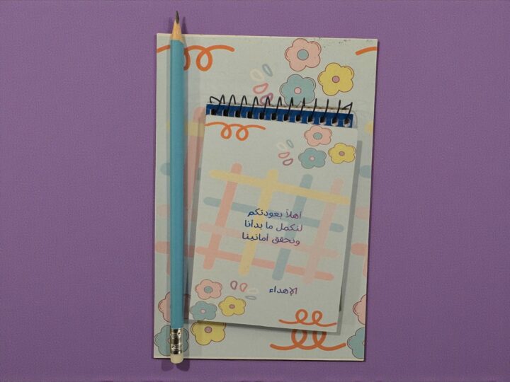 توزيعة نوت مع نوت صغير وقلم رصاص أزرق فوق الكرت