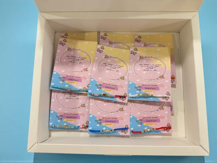 Presentation box filled with colorful card favors and bracelets – Nowme Kuwait