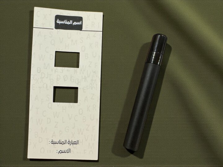 Close-up of perfume favor bottle with beige card