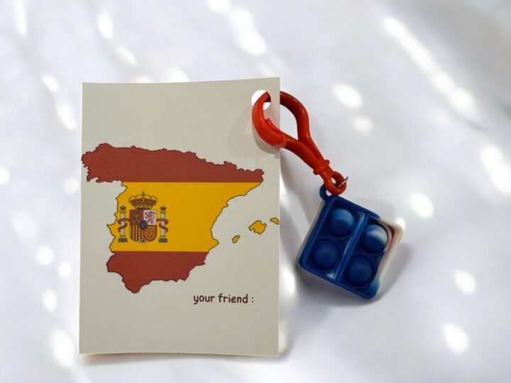 Spain flag favor card with “your friend” text and pop-it keychain
