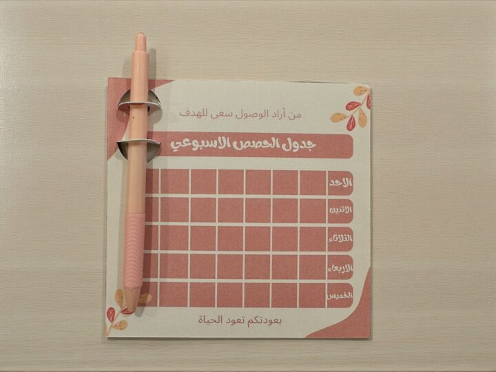 Dark pink weekly study schedule card with blue ink pen